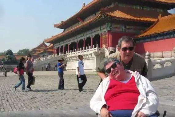 supportive husband Andy travels around the world with his half-paralyzed wife