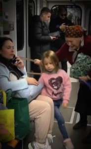 The little girl offered her seat on the subway to her grandmother