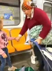 The little girl offered her seat on the subway to her grandmother